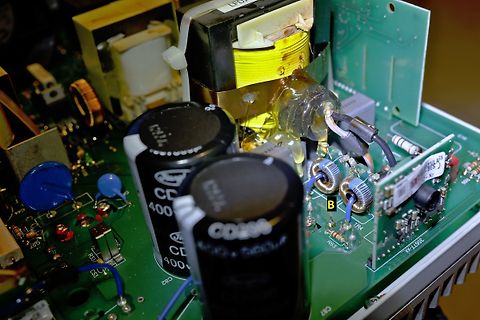 Nahaufnahme einer Leiterplatte mit Elektrolytkondensatoren und Transformator