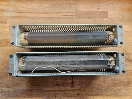 Zwei Heizstäbe in Metallgehäusen auf Holzuntergrund