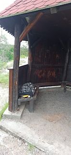 Holzhütte mit Bank und Rucksack