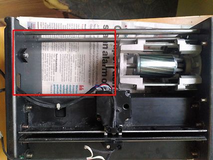 Innenansicht eines elektronischen Geräts mit Zeitung im Hintergrund