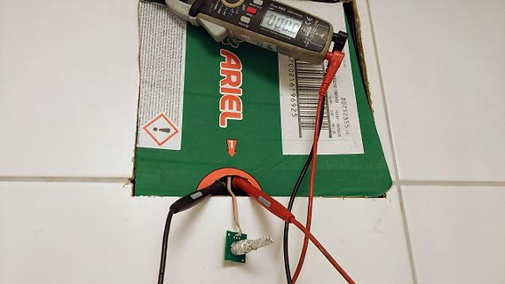 Multimeter misst an kleiner Platine auf Karton