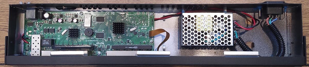 Innenansicht eines MikroTik Netzwerkgeräts mit Netzteil