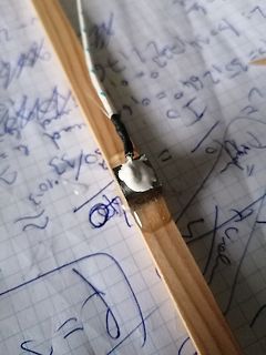 Bauteil mit Kabel auf Holzbrett und Notizen