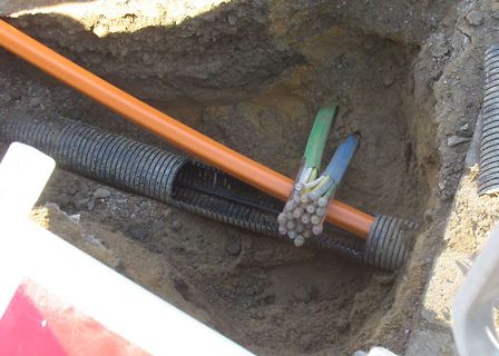 Kabel und Rohre in einem Erdloch