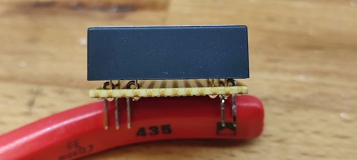 Elektronikbauteil auf rotem Werkzeug