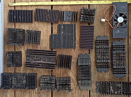 Verschiedene schwarze Kühlkörper auf Holzuntergrund
