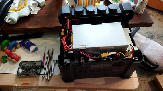 Geöffnetes elektronisches Gerät mit internem Netzteil und Werkzeug