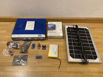 Elektronikkomponenten, Solarpanel, WLAN-HDMI-Stick und Akku auf Holztisch