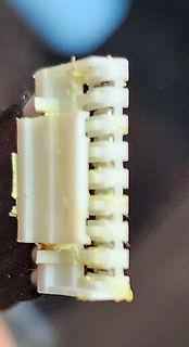 Weißer Kunststoffstecker mit gelblichen Rückständen