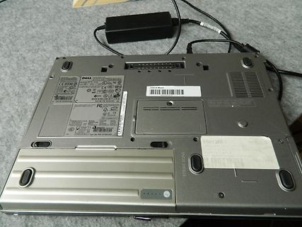 Unterseite eines Dell Laptops mit Netzteil