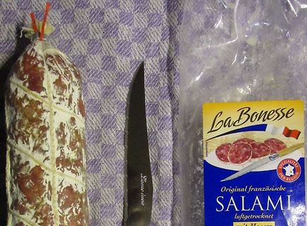 Salami und Messer auf Tischdecke