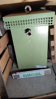 Grünes Metallgehäuse mit Typenschild und Lineal