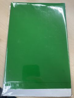 Grüne Mappe in Plastikfolie auf Holztisch