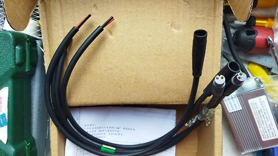 Schwarze Kabel mit Steckern in einem Karton
