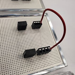 Steckverbinder auf Lochrasterplatine mit rotem Kabel