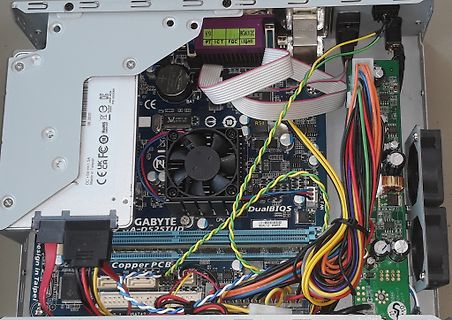 Innenansicht eines Computergehäuses mit Mainboard und Kabeln