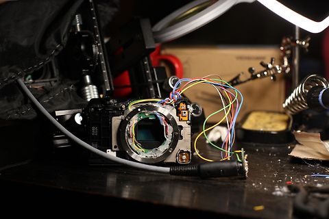 Zerlegte Kamera mit freiliegenden Kabeln und Elektronik
