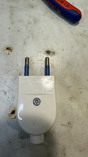 Weißer Netzstecker auf Werkstattuntergrund