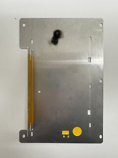 Metallplatte mit Brandspuren und gelben Markierungen