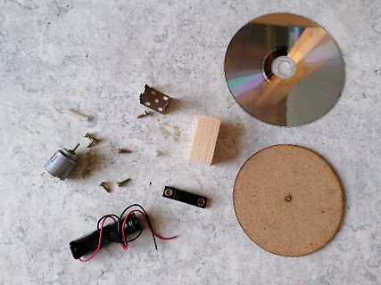 Verschiedene Kleinteile, Motor, Batterie und CD auf Tisch