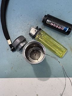 Batterie, Feuerzeug und Metallbehälter mit Drähten