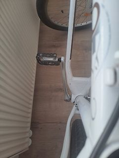 Teil eines weißen Fahrrads neben einem Heizkörper