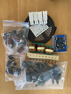 Elektronikbauteile, LED-Streifen und Transformator auf Holzuntergrund