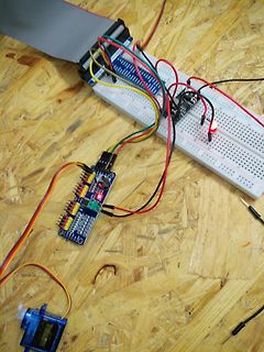 Elektronik-Aufbau mit Breadboard, Mikrocontroller und Motortreiber auf Holzuntergrund