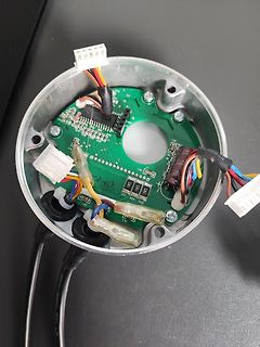 Geöffnete Elektronik mit grüner Leiterplatte und Kabeln