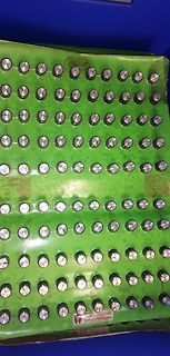 Grüne Oberfläche mit vielen metallischen Zylindern