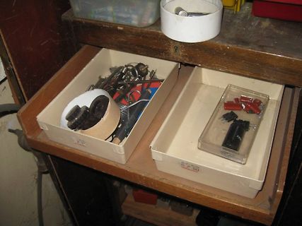 Offene Schubladen mit Elektronikbauteilen und Werkzeug