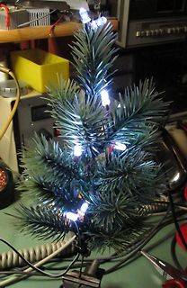 Beleuchteter kleiner Tannenbaum auf Werkstattuntergrund