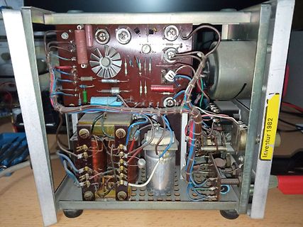 Innenansicht eines alten Netzteils mit Transformator und Platine