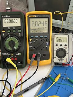 Drei Multimeter und Messaufbau auf Tisch