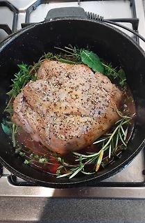 Fleisch in einem gusseisernen Topf mit Kräutern