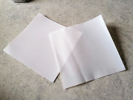 Zwei weiße Papierbögen auf einem Boden