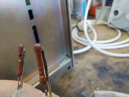 Zwei braune Bauteile mit farbigen Markierungen