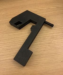 3D-gedrucktes schwarzes Bauteil auf Holzuntergrund