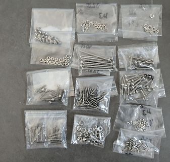 Verschiedene kleine Schrauben und Muttern in Plastikbeuteln