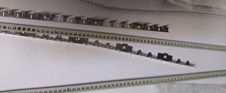 Metallschienen mit Lochreihen und Clips