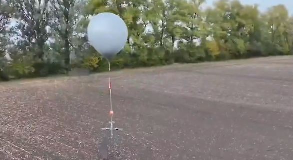 Weißer Ballon über einem Feld