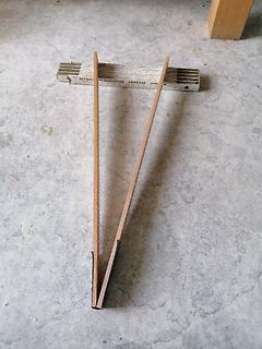 Zwei Holzleisten und ein weißes Bauteil auf Boden