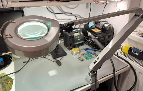 Elektronik-Werkstatt mit Vergrößerungsleuchte und Lötkolben