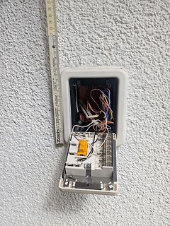 Offene elektrische Anschlussdose mit Verdrahtung und Maßstab
