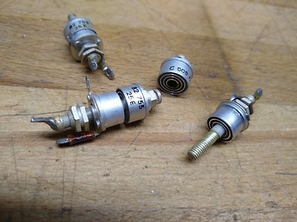 Vier elektronische Bauteile auf Holzuntergrund