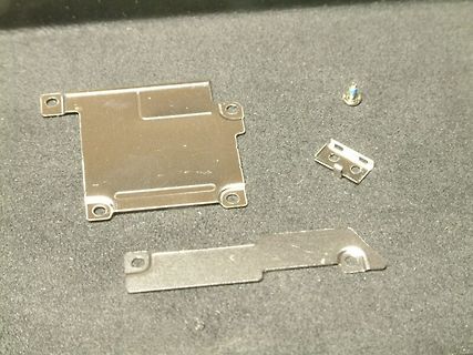Metallteile und eine Schraube auf Untergrund
