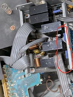 Innenansicht eines elektronischen Geräts mit Flachbandkabeln und Relais