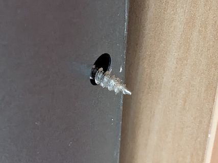Schraube in einer dunklen Platte