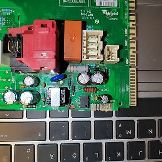 Nahaufnahme einer grünen Leiterplatte mit elektronischen Bauteilen