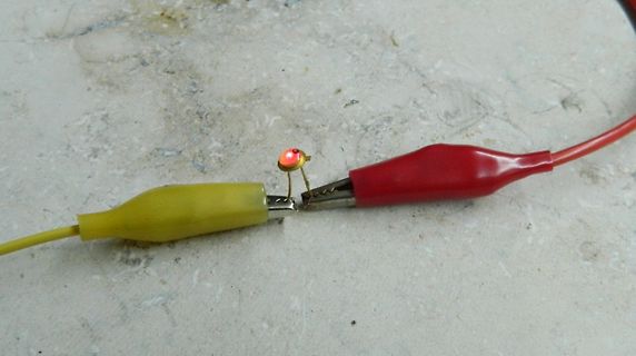 Messaufbau mit leuchtender LED zwischen Krokodilklemmen